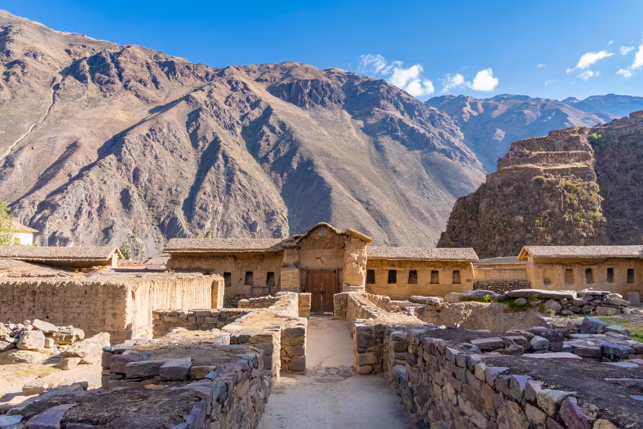 Construcciones de piedra y adobe en Ollantaytambo, rodeadas por las laderas montañosas del Valle Sagrado.