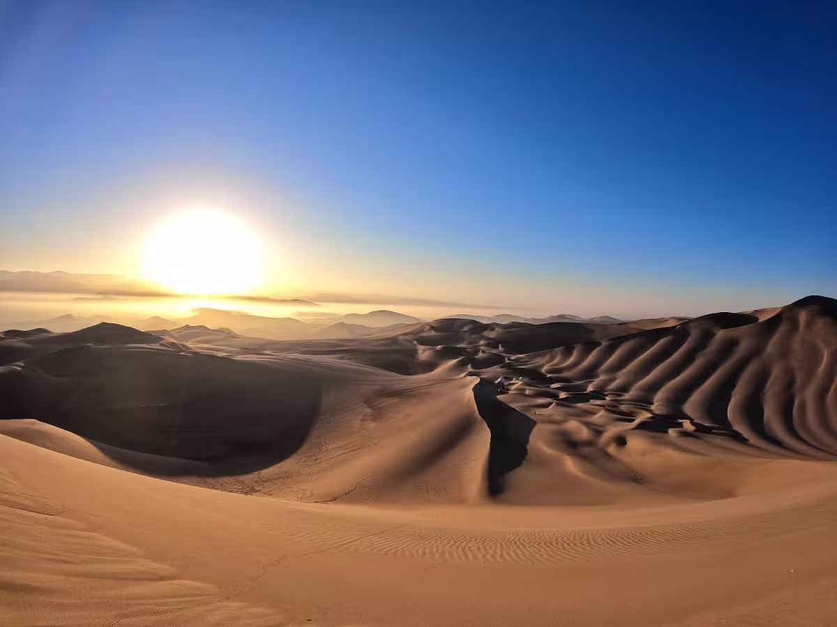 Vista del oasis de Huacachina rodeado de dunas en el desierto de Ica, Perú.