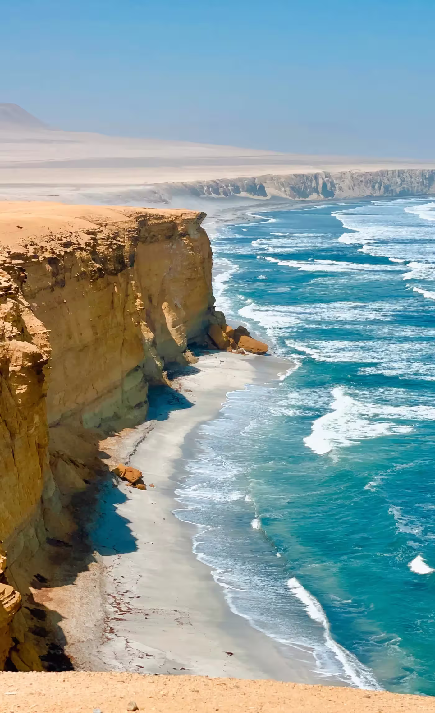 Acantilados de costa desértica frente al océano Pacífico en Paracas, Perú.