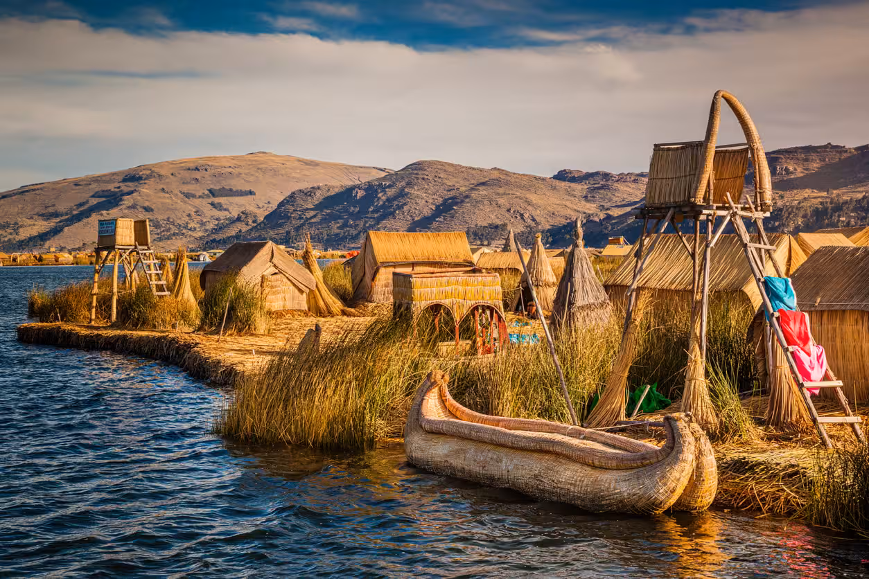 Construcciones y una embarcación de totora junto al agua en las islas de los Uros, lago Titicaca.