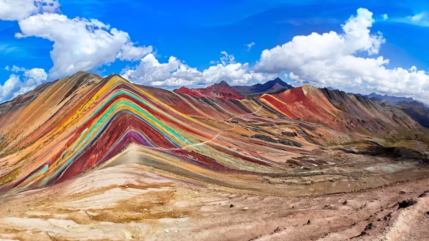 Montaña de Siete Colores en Vinicunca, rodeada por paisajes de altura de los Andes peruanos.